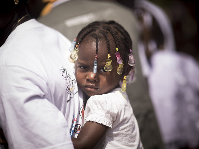 Photo: Little girl at the back of caregiver