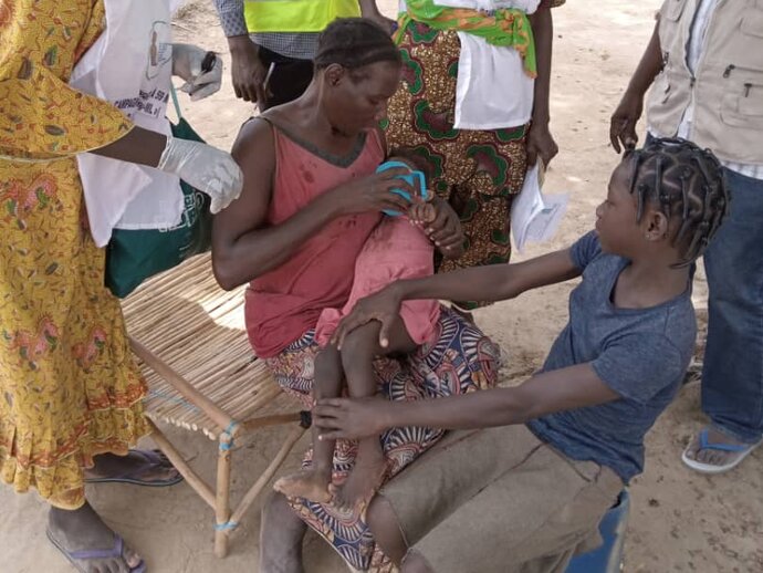 Photo: Mother administering SMC to child