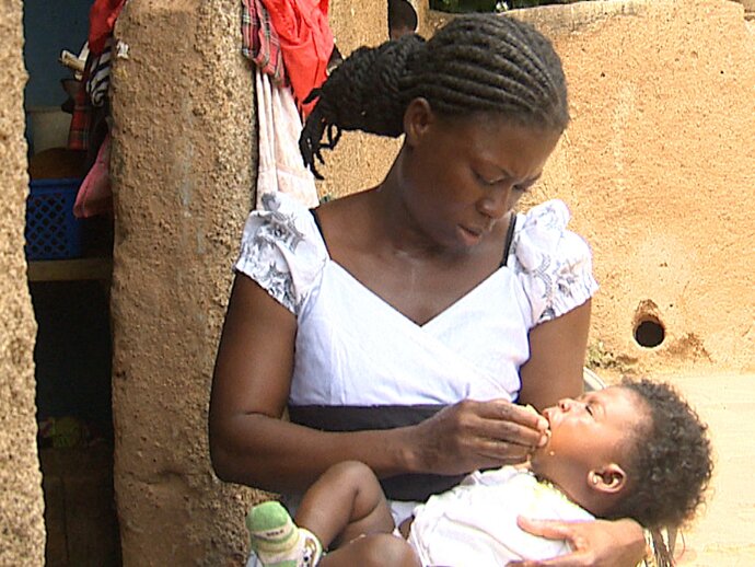 Photo: mother administering SMC to baby