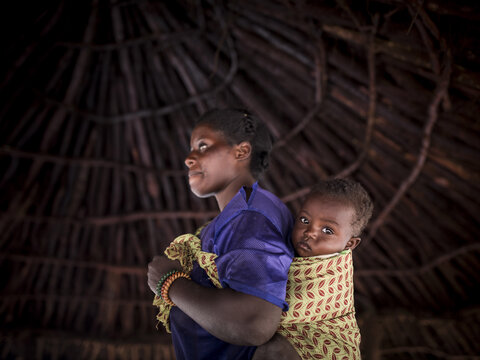 Photo: Mère africaine avec enfant à l'arrière