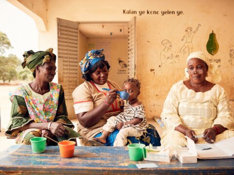 Photo: Community health workers with family delivering SMC