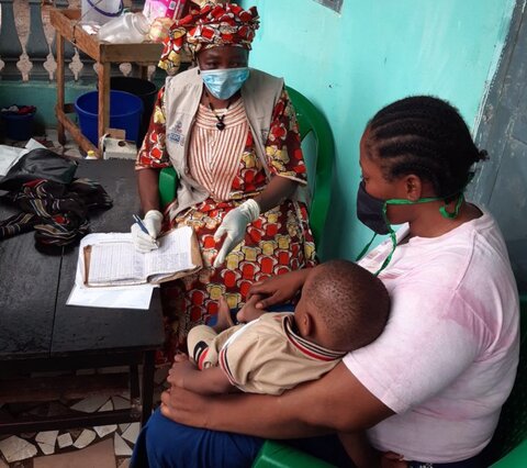 Photo: mother, child and healthworker administering SMC